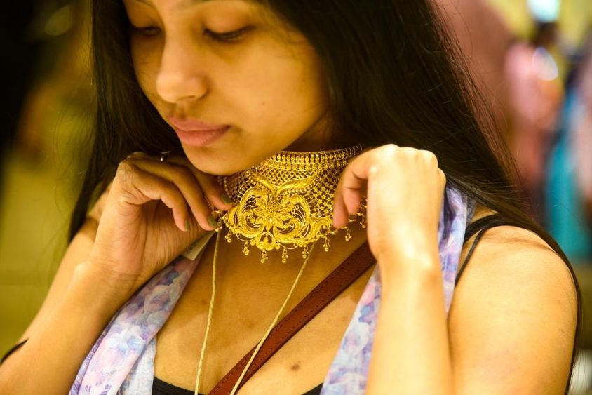 Egy nő ékszereket próbál ki a Dhanteras alkalmából.