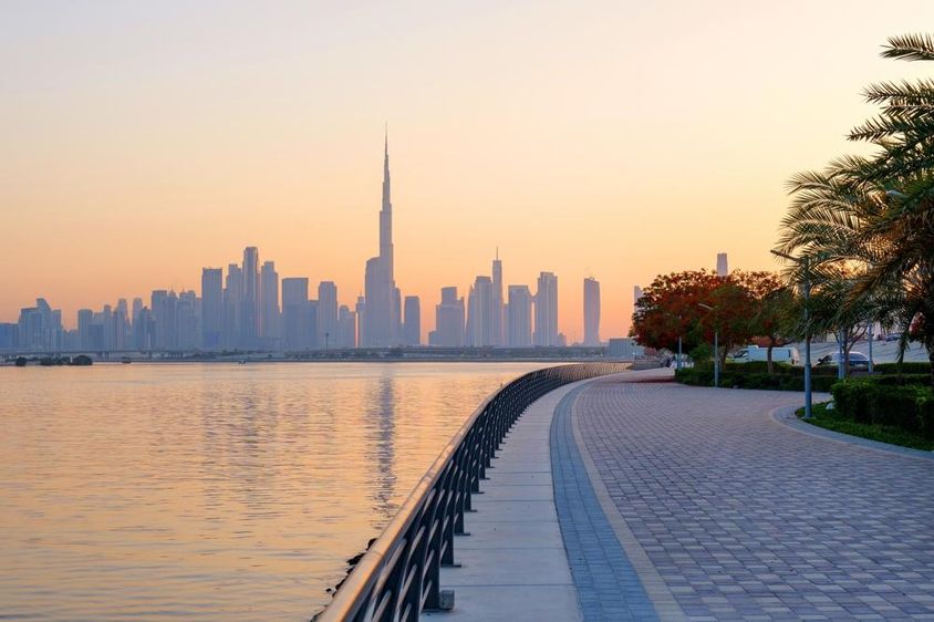 Gyönyörű rakpart virágzó fákkal, kilátással Dubai belvárosára.