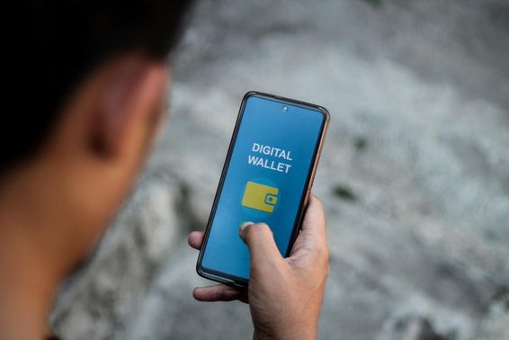 A person's hand displaying a smartphone screen showing digital wallet applications interface.