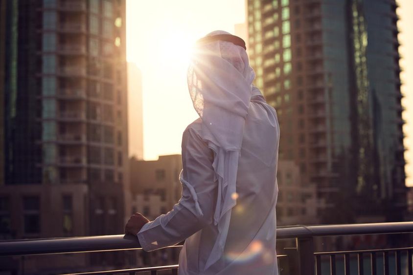 Arab férfi nézi a napnyugtát Dubaiban.