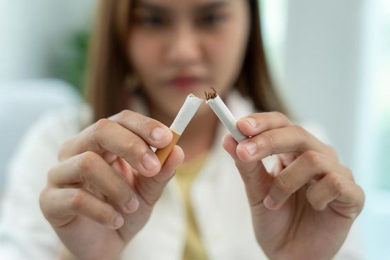 Nincs dohányzás, egy nő ketté tőri a cigarettát. 