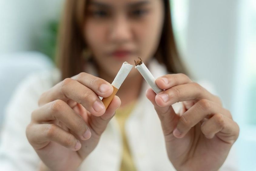 禁止吸烟，一名女子把一支烟折成两半。
