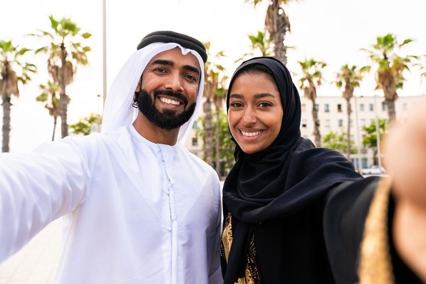 Hagyományos arab pár emírségi ruhában randevúzik a szabadban.