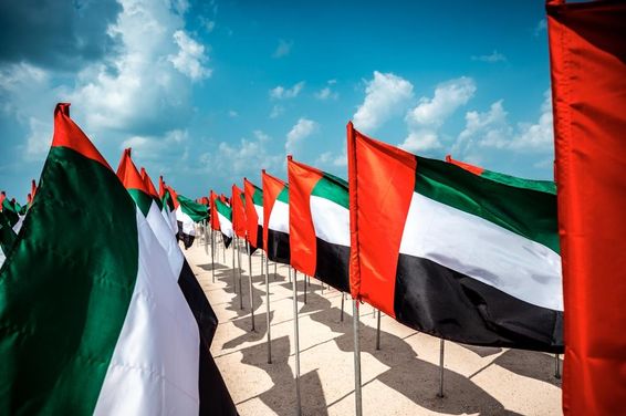 Egyesült Arab Emírségek zászlói lengnek a szélben egy népszerű strandon Dubaiban.