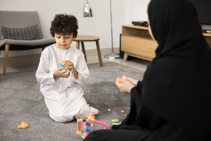Fiatal arab nő kreatív játékokkal tanít egy muszlim otthonban.