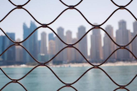Kilátás a felhőkarcolókra Dubaiban a vasrácsokon keresztül.