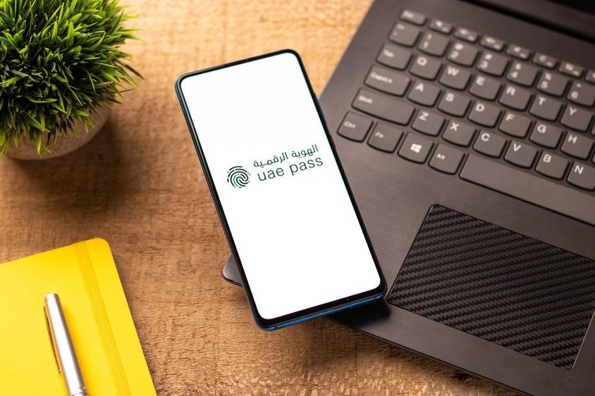 UAE Pass logo on a phone screen.