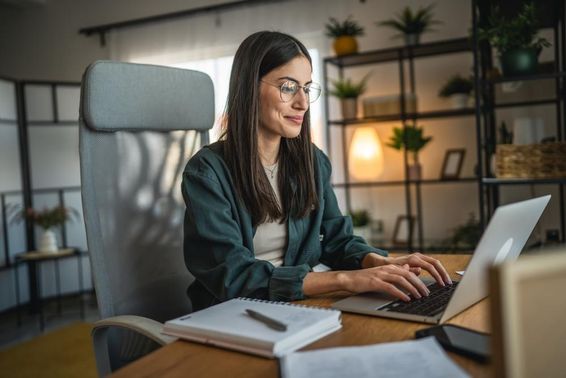 Felnőtt nő dolgozik laptop és használja notebook otthoni irodában.