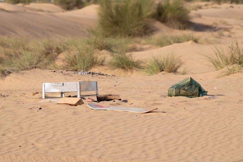 Fém, műanyag és egyéb szemét, amit az emberek hátrahagytak, szennyezi a sivatagi környezetet Dubaiban.