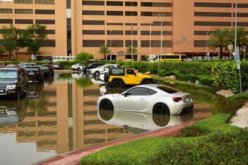 Cars in a rain-soaked parking lot in Dubai.