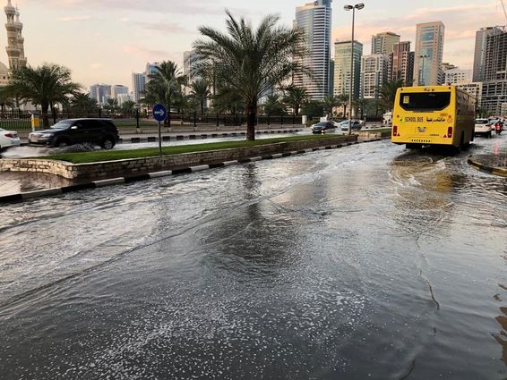 Járműforgalom halad át egy elárasztott városi úton Dubaiban.