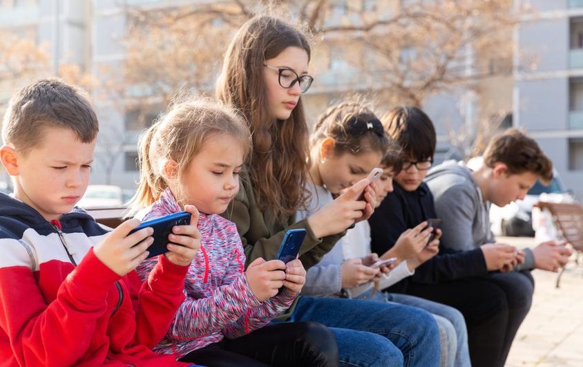 Gyerekek telefonon keresztül kommunikálnak üzenetküldőn keresztül.