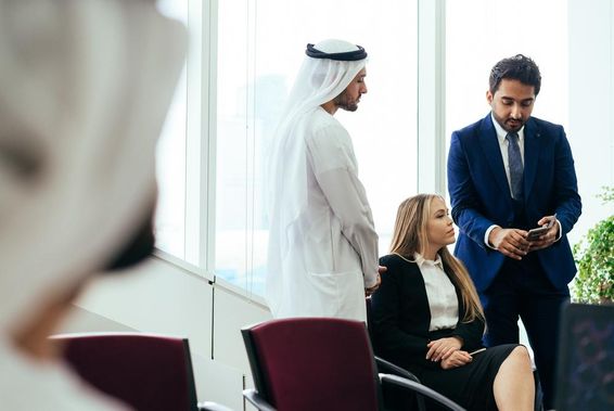 Többnemzetiségű üzleti csapat dolgozik együtt egy dubai irodában.