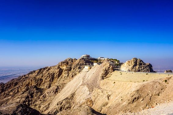 Al Ain Jabal Hafeet hegyi táj csúcsok és épületek.