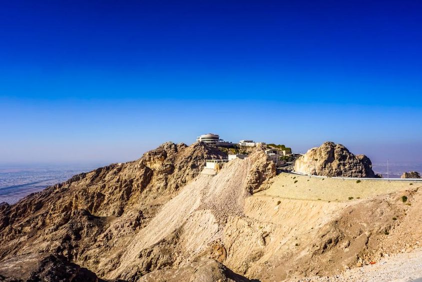 Al Ain Jabal Hafeet hegyi táj csúcsok és épületek.