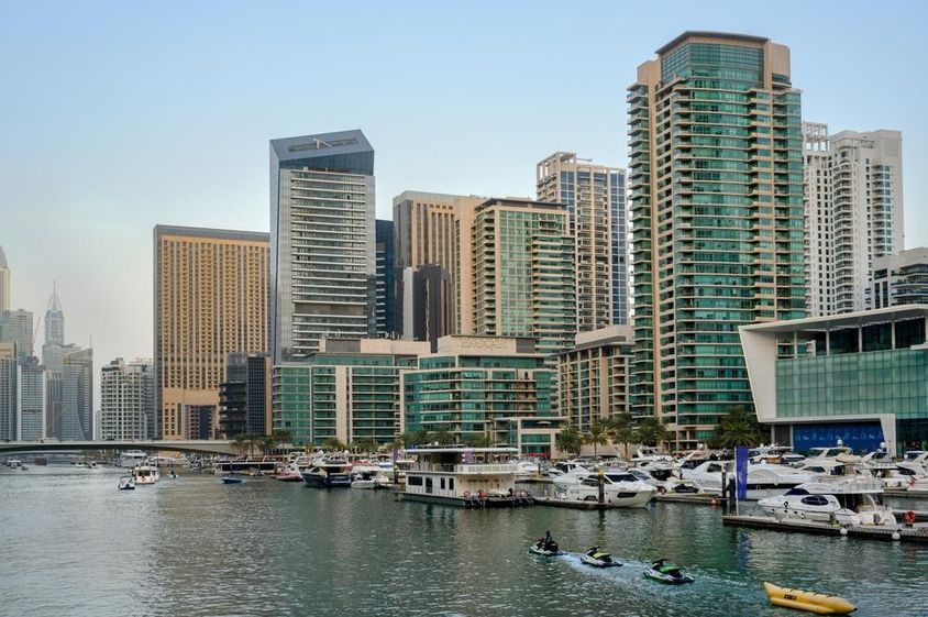 Esti kilátás a csatornára, a kikötőre hajókkal, Dubai sétányára és felhőkarcolóira.