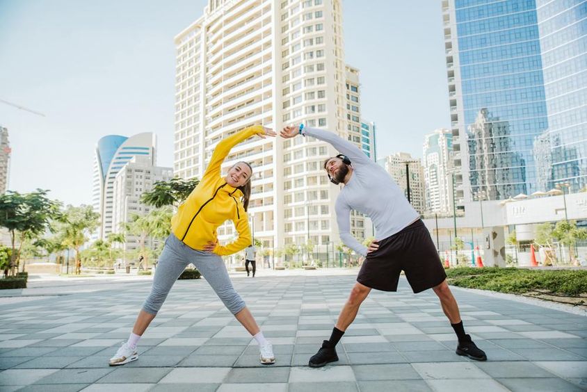 A férfi és a nő együtt nyújtózkodnak edzés után Dubaiban.