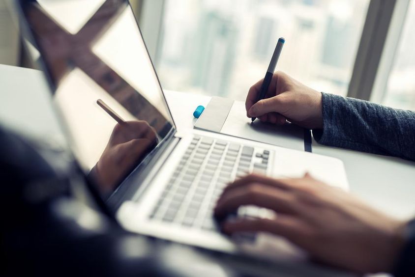 Közeli kép egy laptopon dolgozó férfiról.
