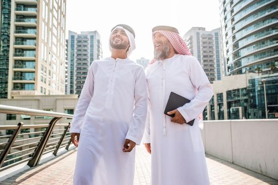 Két hagyományos emirátusi ruhát viselő üzletember találkozója Dubaiban.