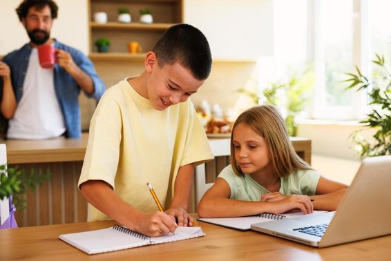 Testvérek házit csinálnak otthon notebookot használnak.