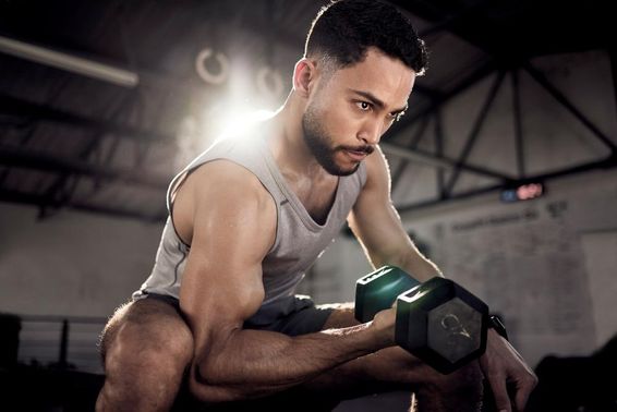 Egy arab sportoló súlyemeléssel vagy bicepszgyakorlatokkal Dubaiban.