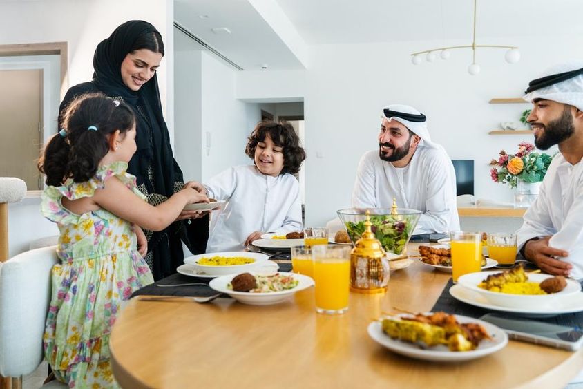 Happy Arab family together at home after dinner during Ramadan.