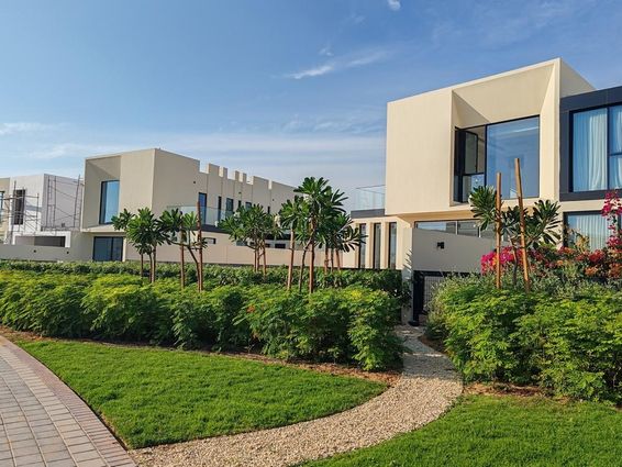 Krémszínű villák fekete üvegablakokkal Dubaiban.