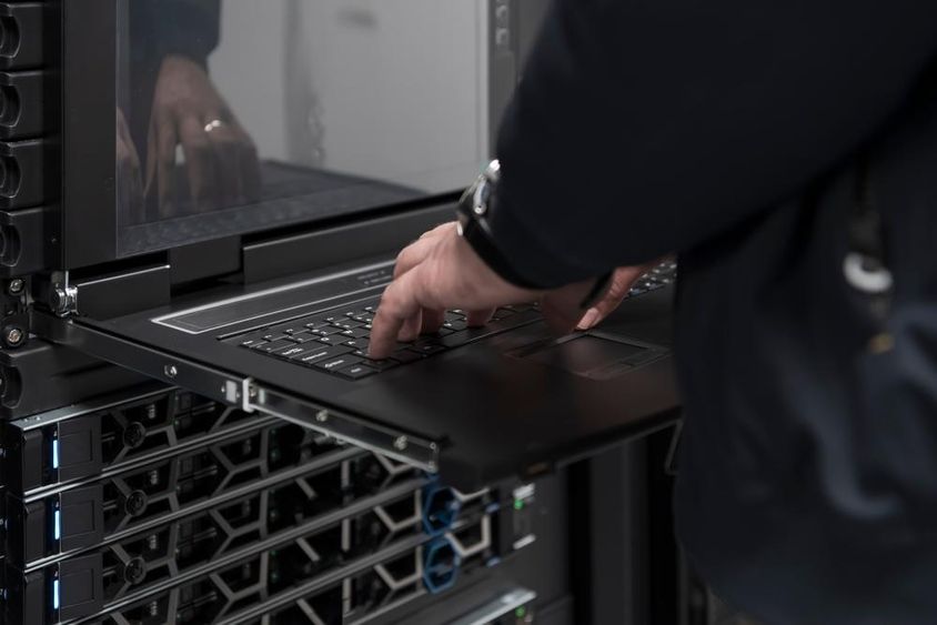 An engineer using a supercomputer in a server room.