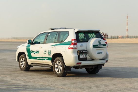 Dubai rendőrkocsi áll a betonon.