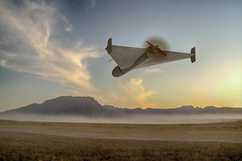 Un drone militaire kamikaze survolant des montagnes désertiques.