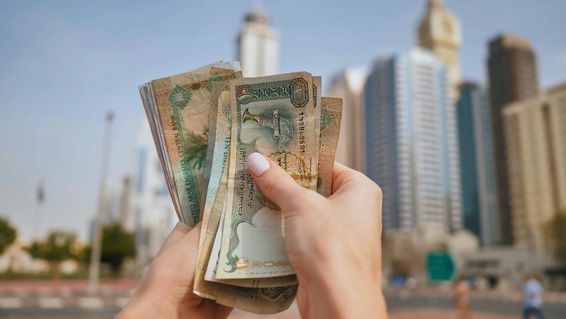 az Egyesült Arab Emírségek pénze a dubai felhőkarcolók hátterében.