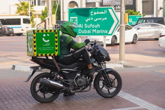 Motoros futár a környezetbarát Careem zöld kézbesítő szolgáltatástól.