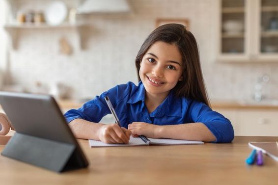 Boldog iskoláslány otthonról tableten keresztül tanul