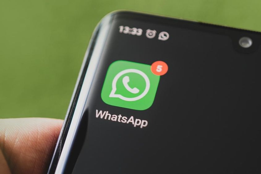 Иконка WhatsApp на экране черного смартфона.