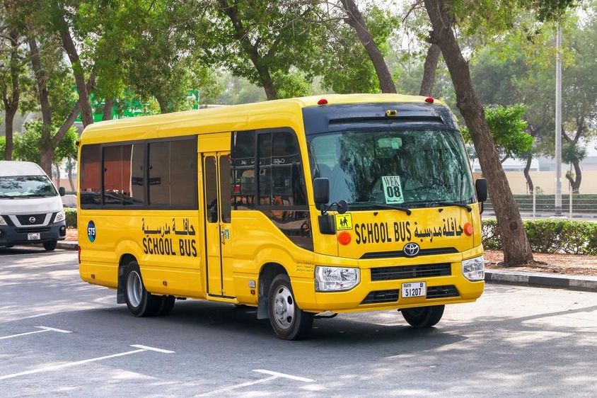 दुबई की एक सड़क पर टोयोटा कोस्टर स्कूल बस