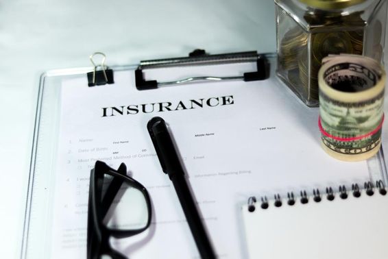 Insurance form with coins and dollar bundle