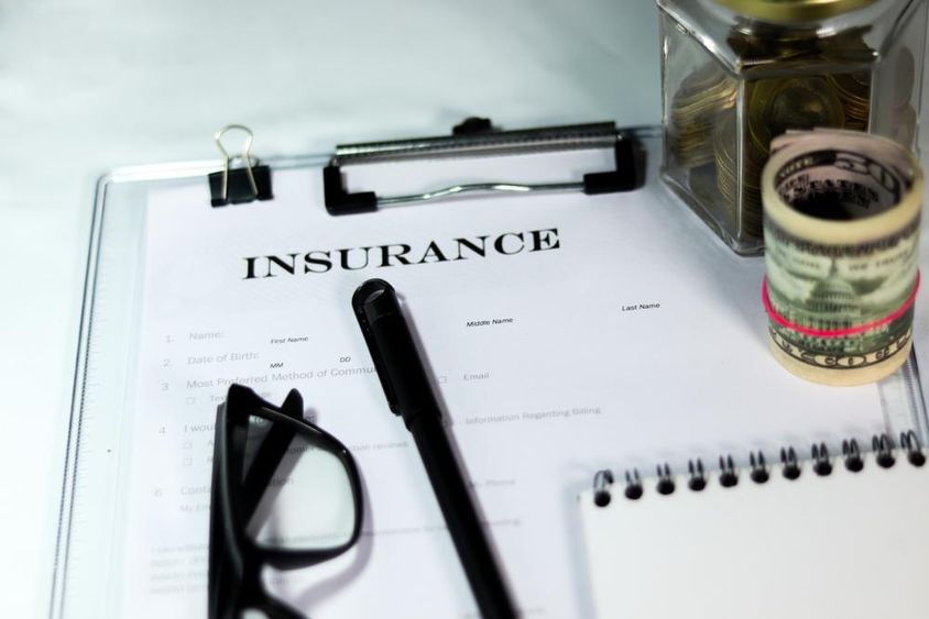 Insurance form with coins and dollar bundle