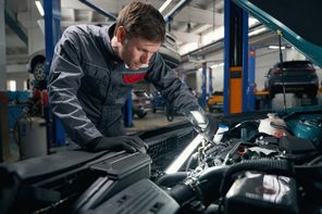 Работник выполняет комплексный технический осмотр автомобиля