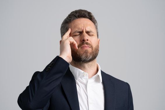 Businessman in a suit having a headache.