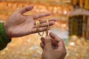 A hand trying on a luxury gold bracelet