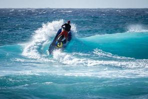Jetski vízre száll egy megtörő hullám felett 