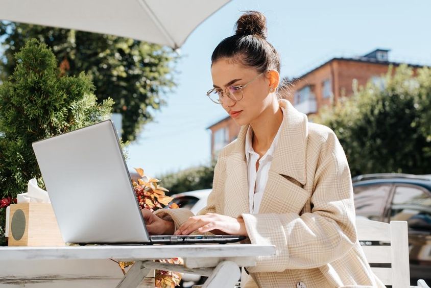 Stylish businesswoman wearing glasses working on a laptop